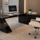 Modern executive office with a glossy black angular-base desk, matching credenza, iMac, and a cream leather high-back chair with wood armrests on a beige rug