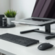 Home office desk setup with wireless keyboard, mouse, and elevated laptop stand